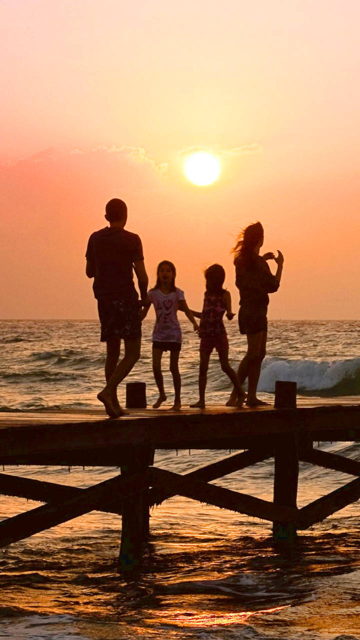 Silhouette of a family on a pier