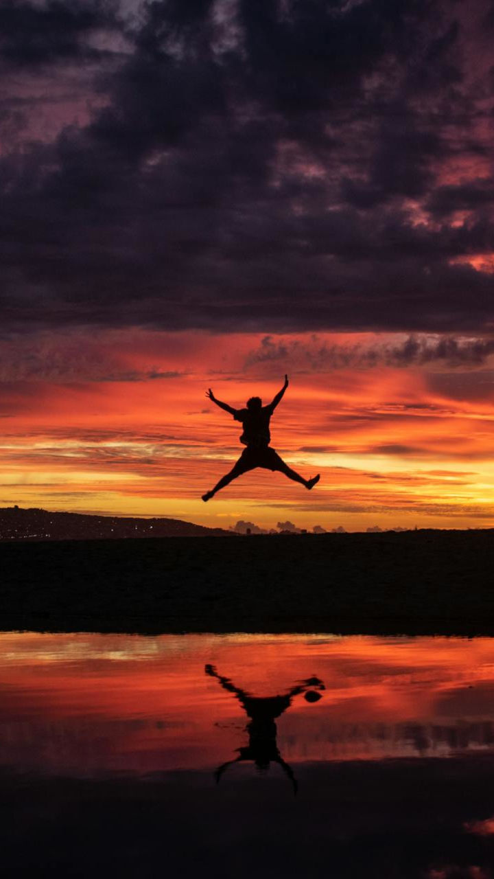 Silhouette of a man jumping in front of a sunset